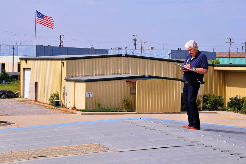 Inspector documenting hail damage on a roof