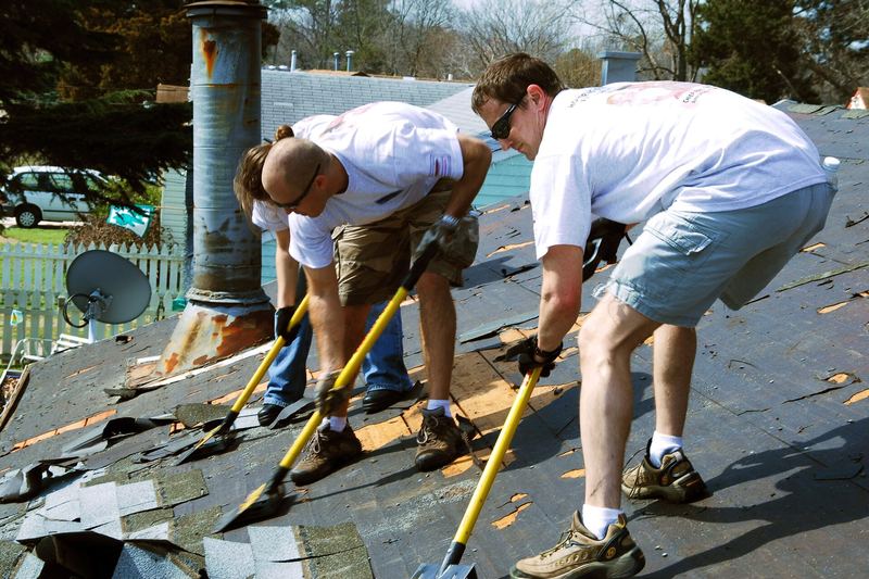 Roofers tearing off an old roof covering